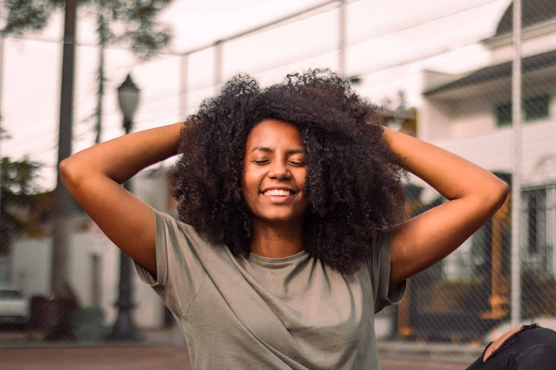 young woman laughing with raised arms