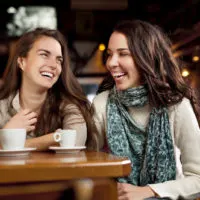two girls talking while sitting in cafe
