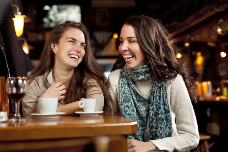 due ragazze che parlano sedute in un caffè