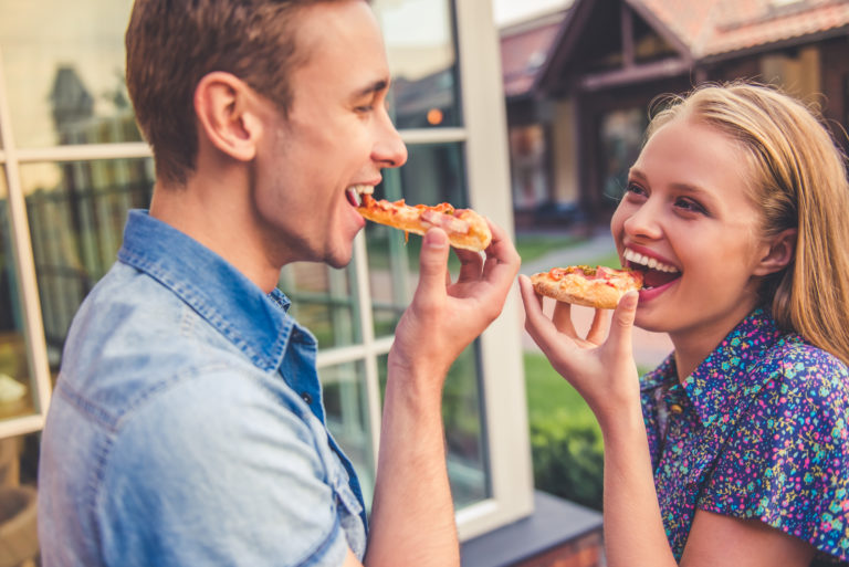 Beautiful young couple is eating pizza