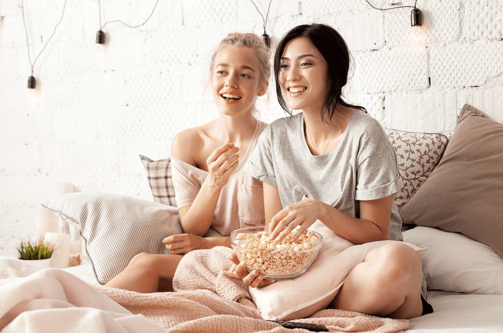 Cheerful friends eating tasty popcorn and looking movie