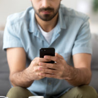 cropped photo of a man texting on phone