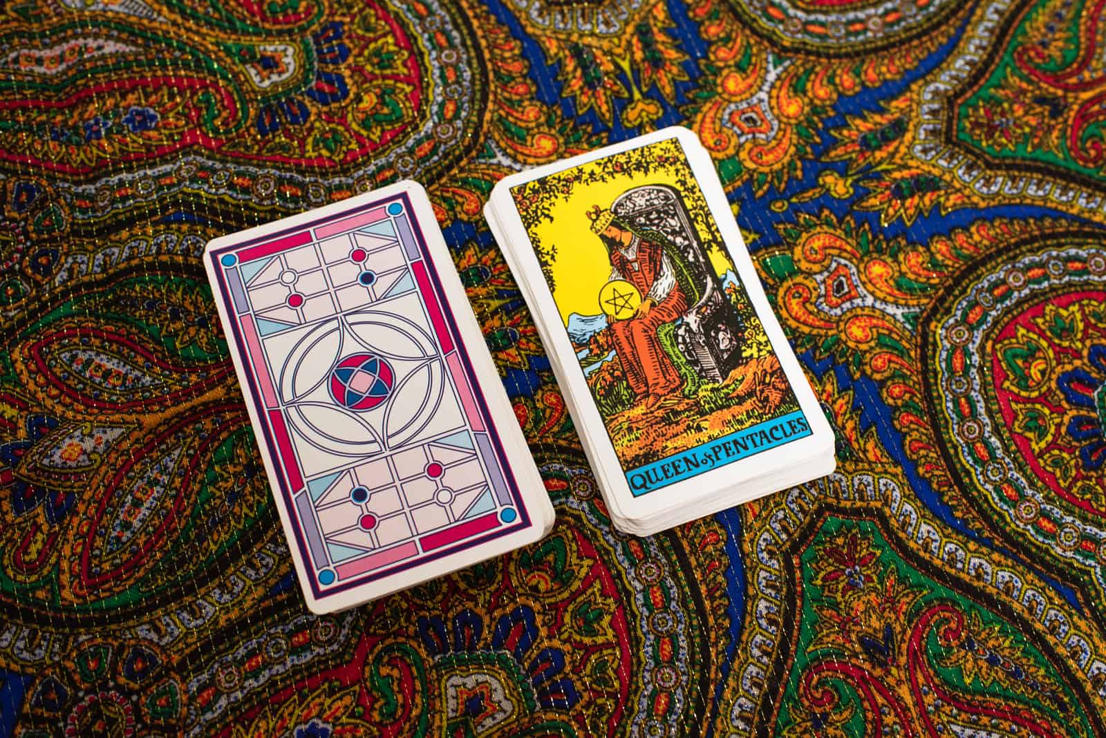 Queen Of Pentacles and deck of cards on table