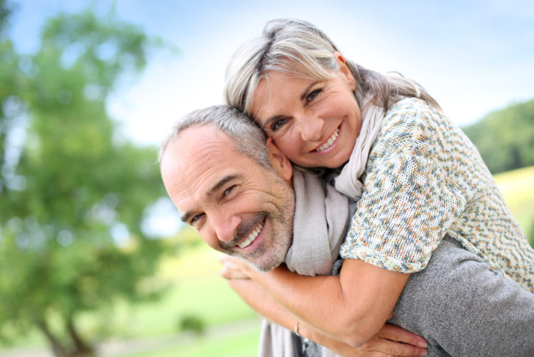 Senior man giving piggyback ride to woman