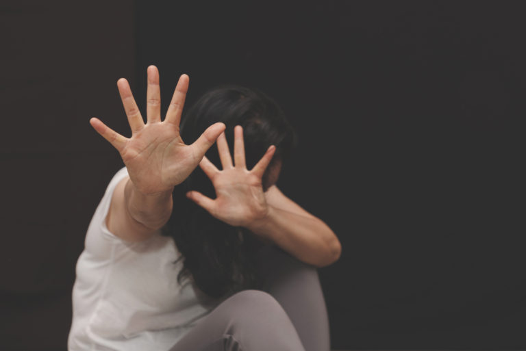 scared woman raising hands in defense