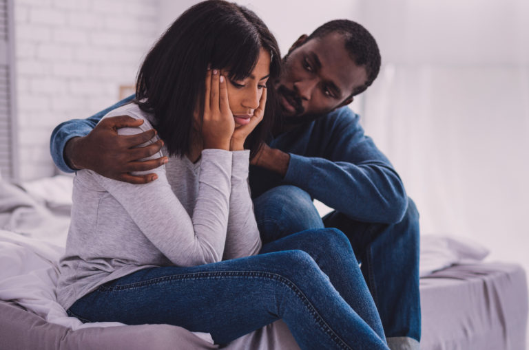 man comforting woman
