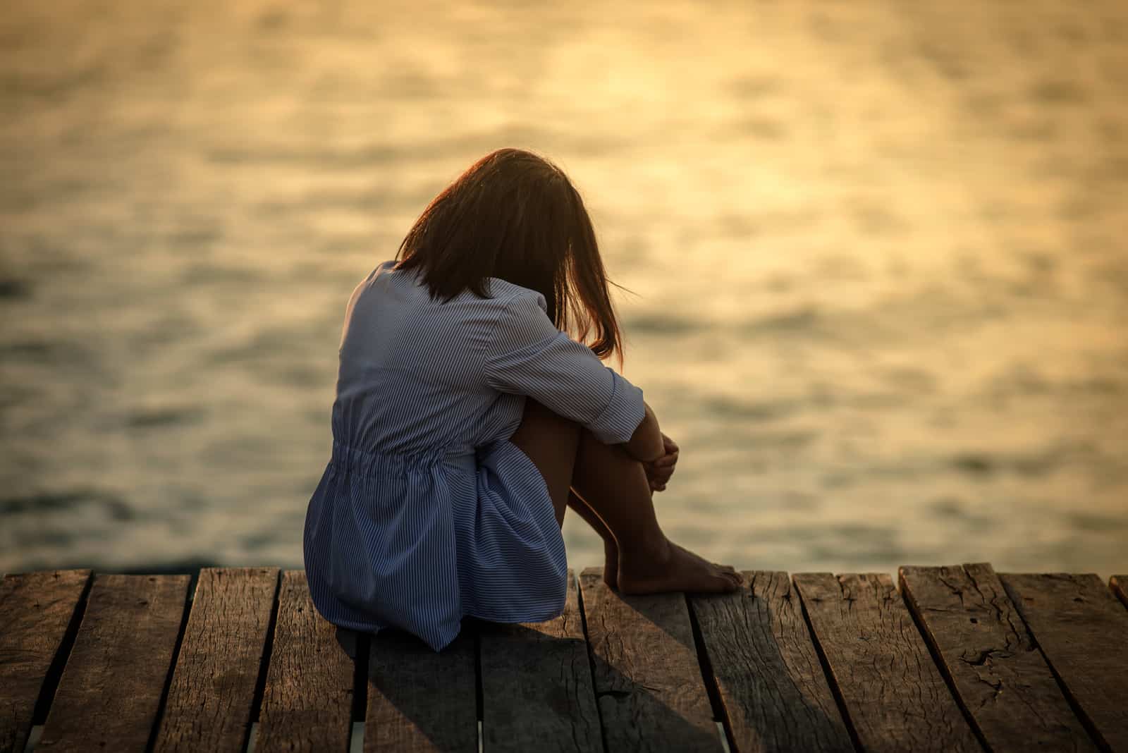 a beautiful woman sitting on a pier