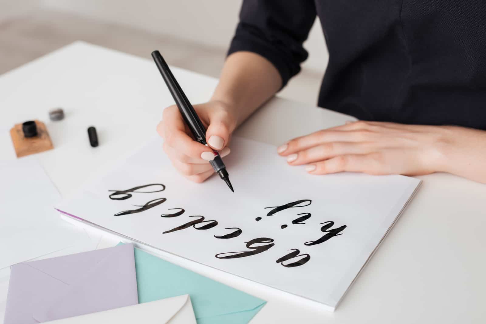 una donna disegna con la calligrafia su carta