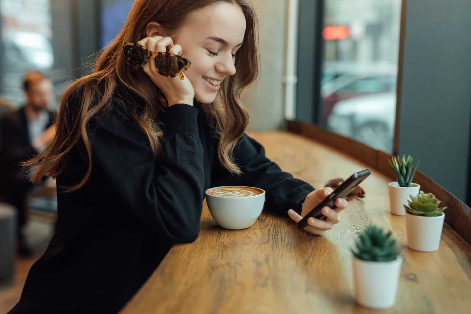 bella ragazza con il pulsante del caffè sul telefono
