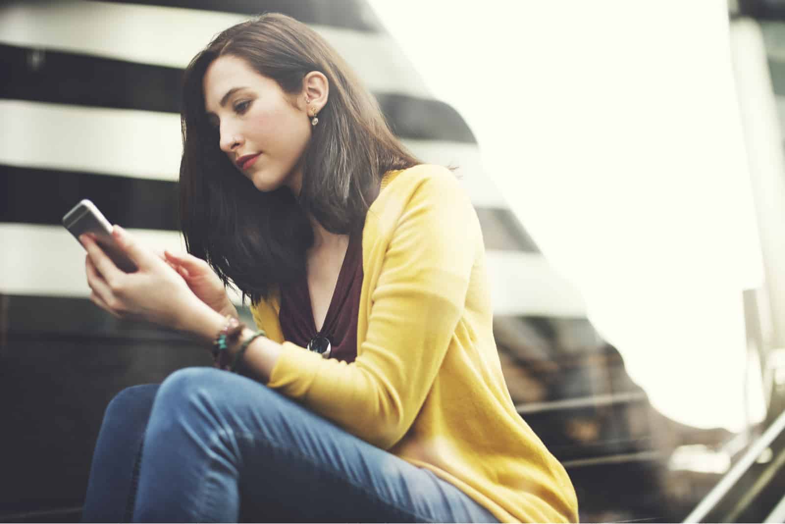 hermosa mujer sentada y clave en el teléfono