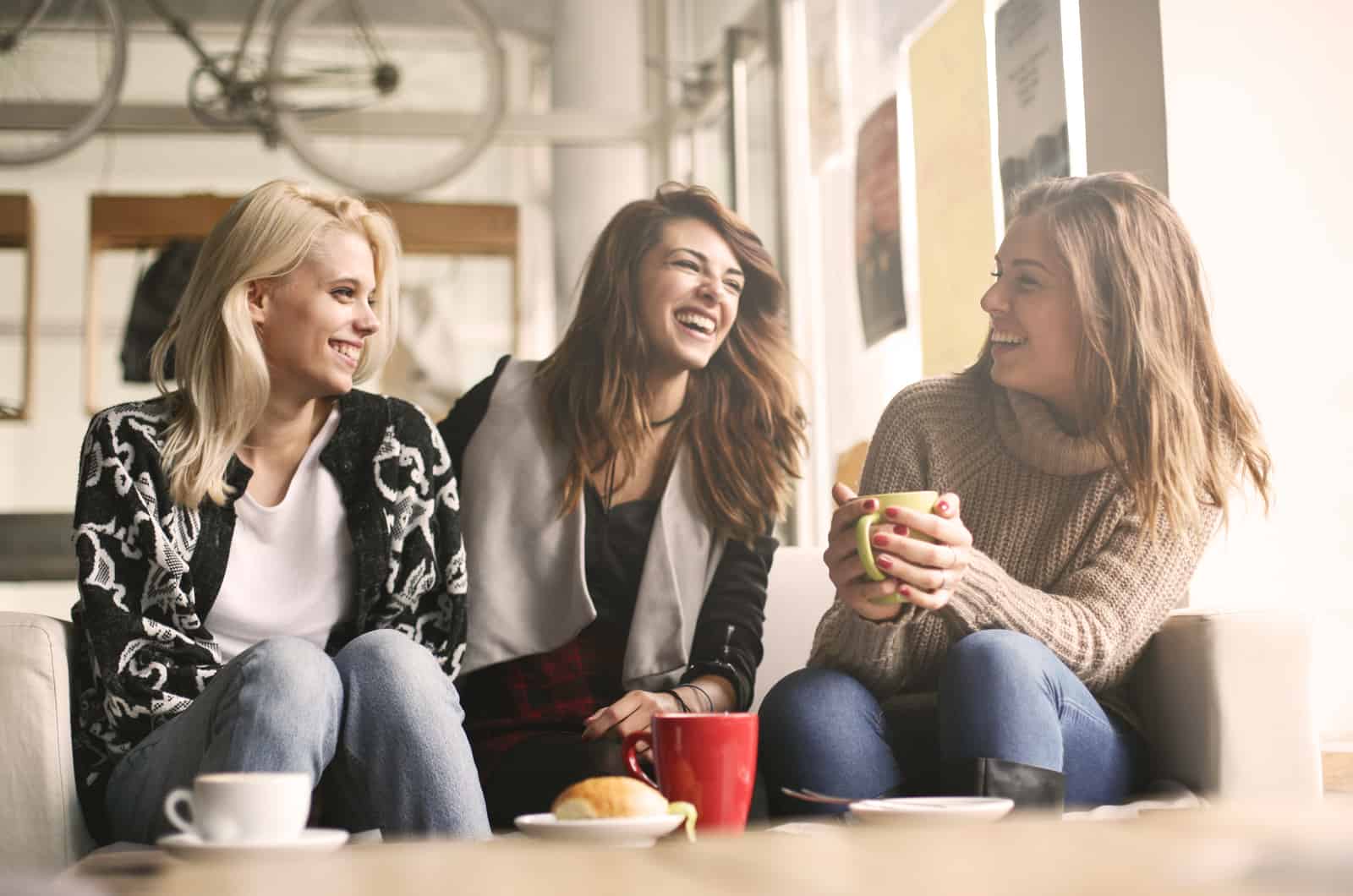 girls sitting at cafe laughing