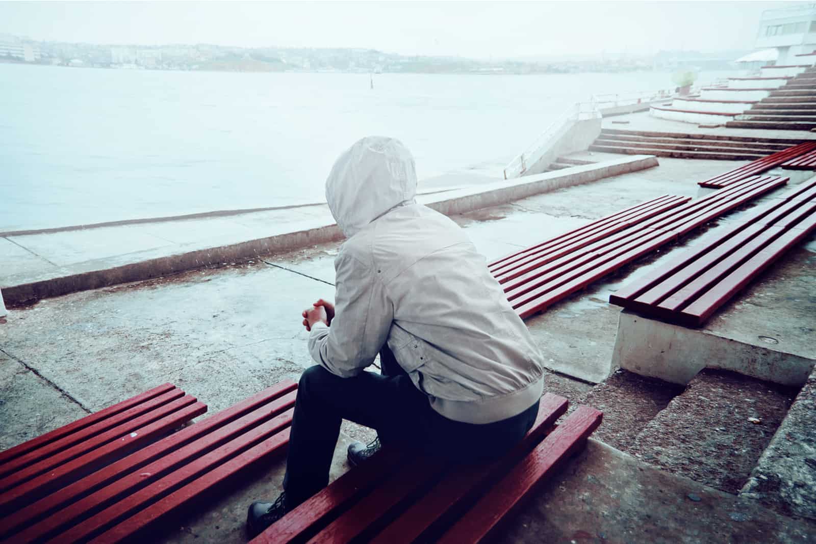 man sitting on bench looking into distance