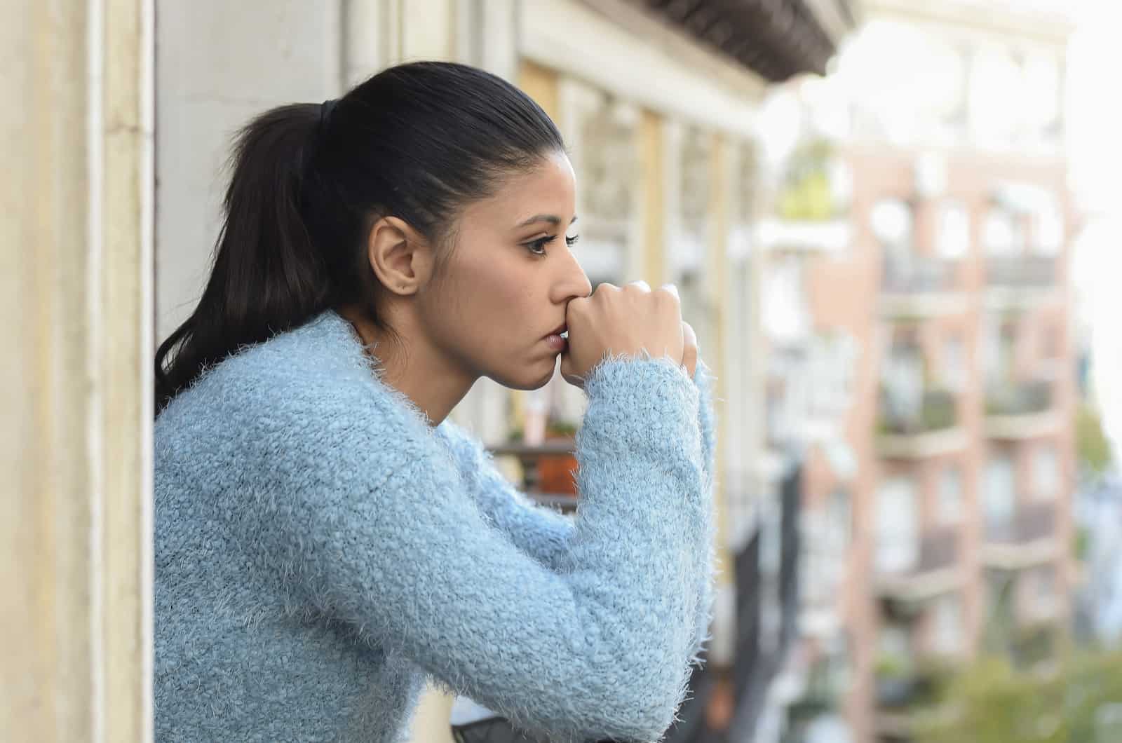 mulher triste com pensamentos profundos a olhar para a rua