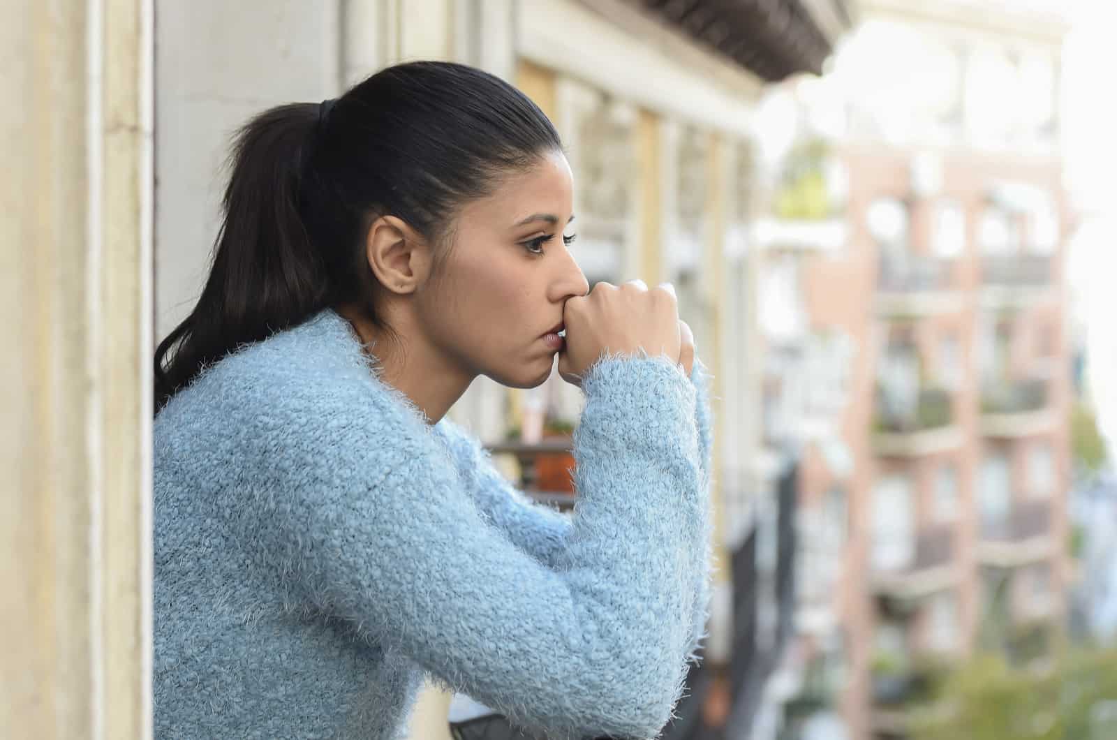 mujer triste y pensativa mirando a la calle