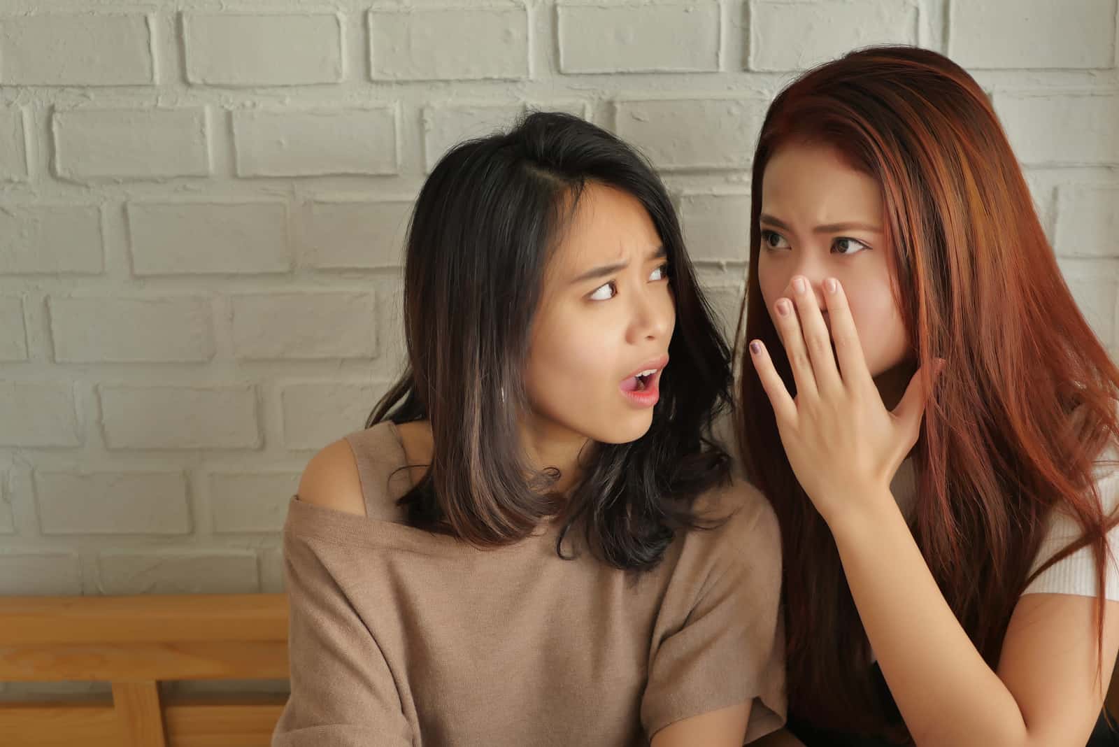 surprised excited woman gossiping to her friend