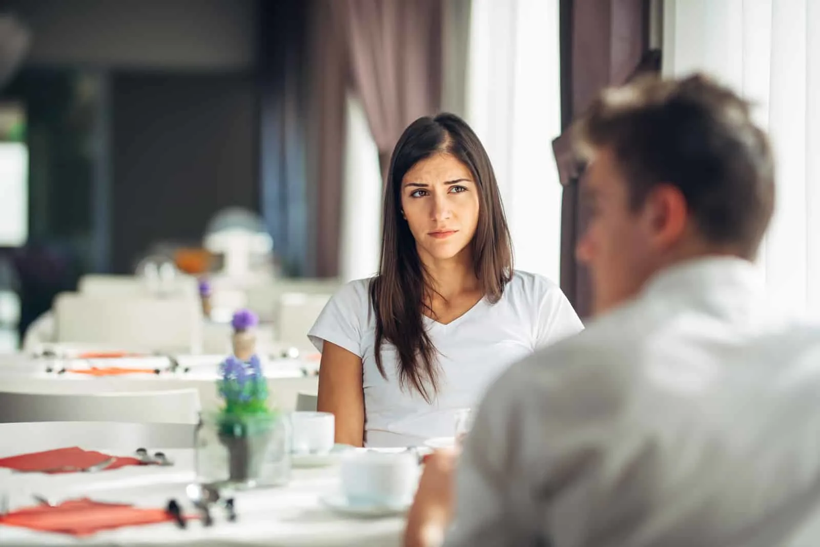 the man looks away as he talks to the woman
