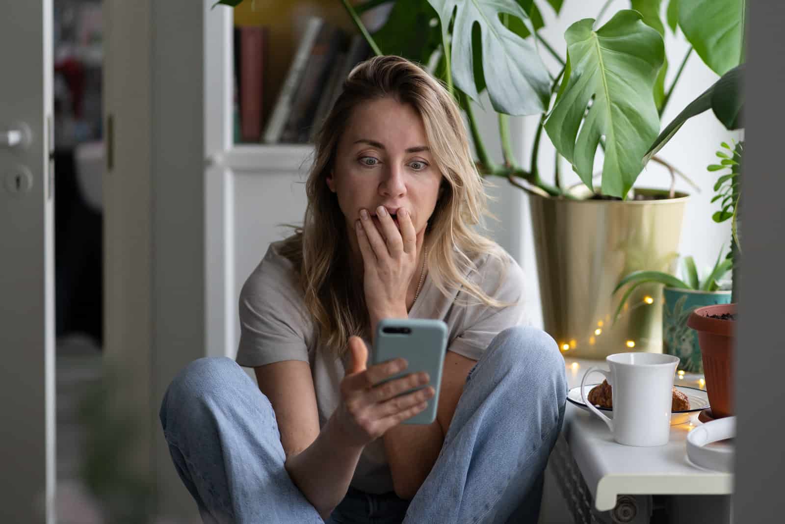 mujer cansada sentada y mirando su teléfono