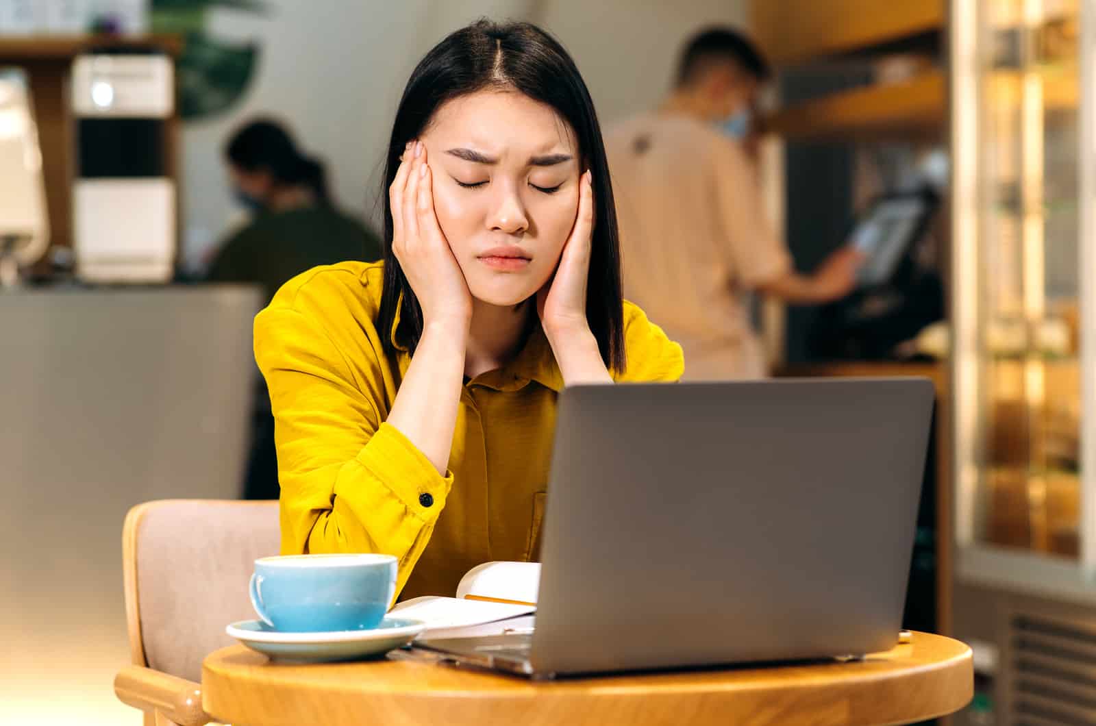 mujer cansada trabajando en un café