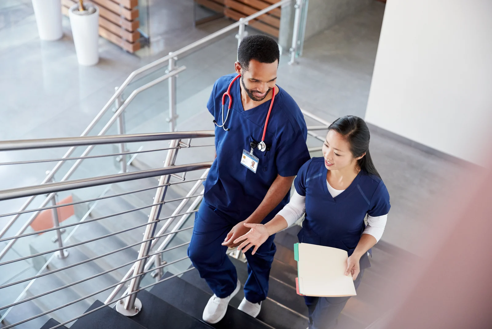 two nurses talking while walking in hallway