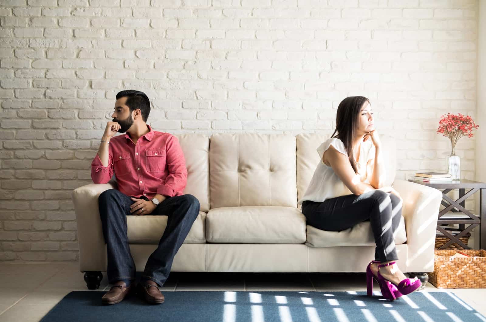 unhappy couple sitting apart on couch