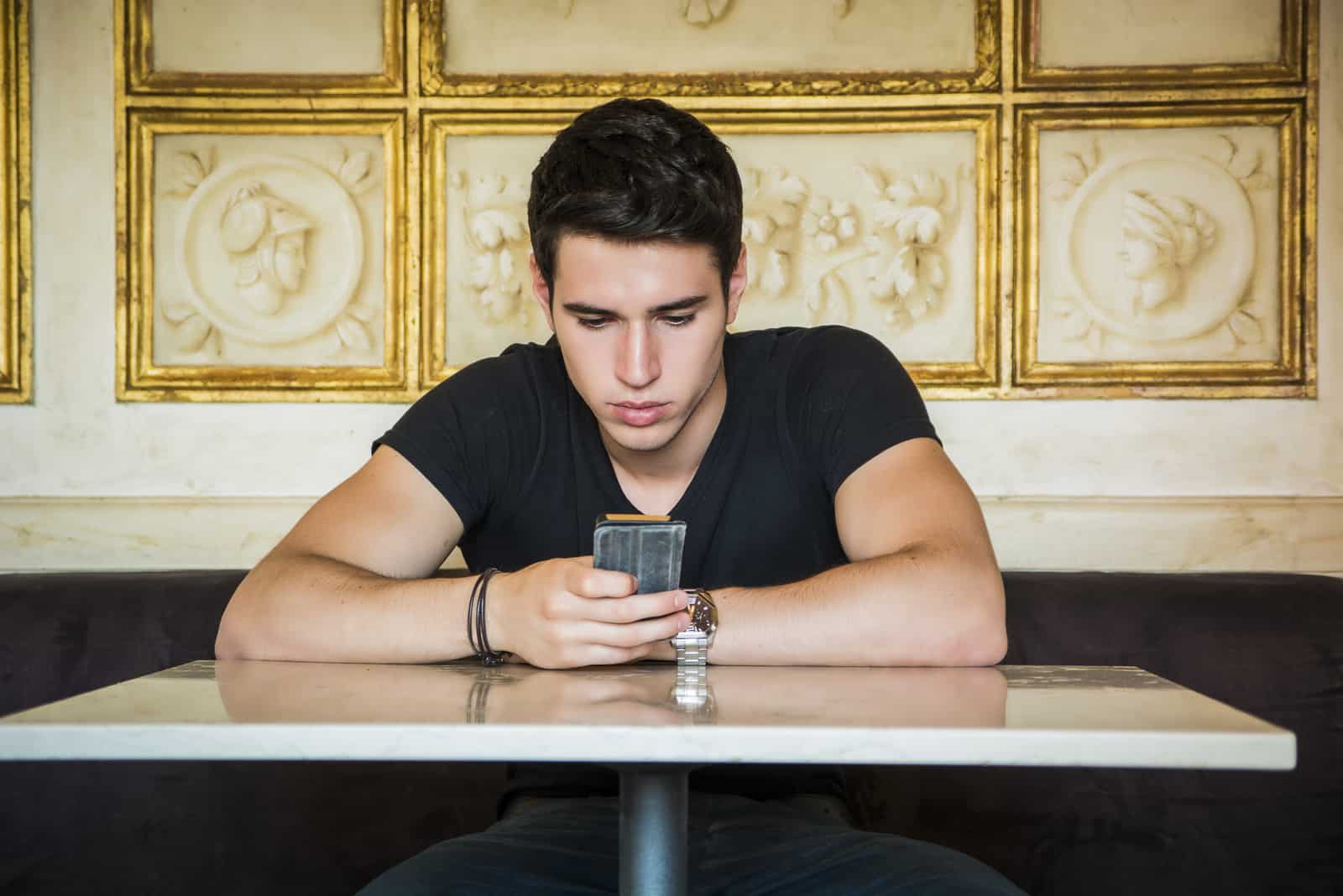 young man texting while waiting for friend