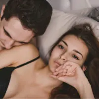 man and woman lying in bed