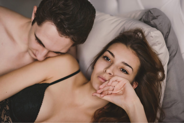 man and woman lying in bed