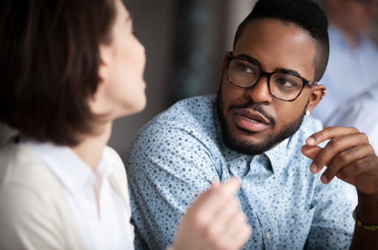 a man sits next to a woman and they talk