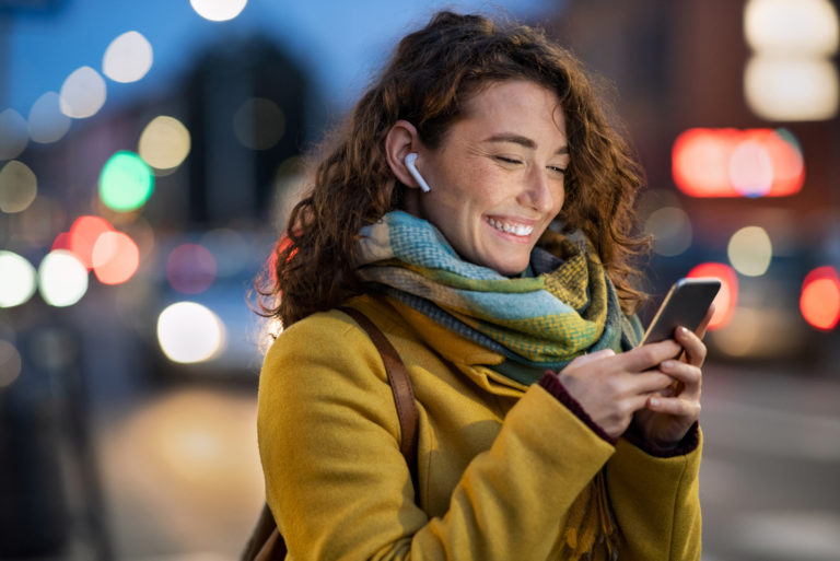 mujer ríe mientras sostiene el teléfono