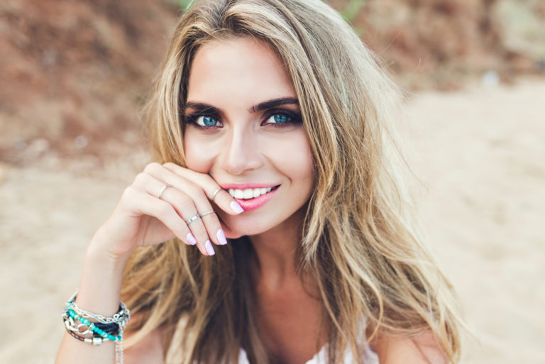 a smiling woman with long blonde hair and blue eyes