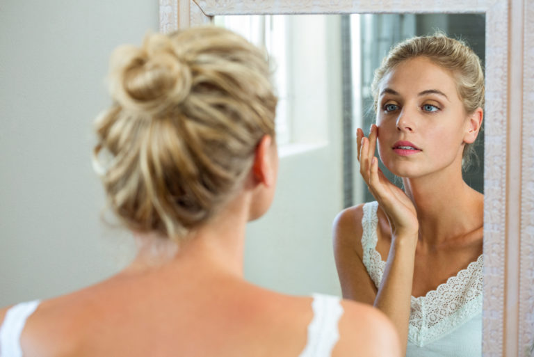 woman looking into mirror