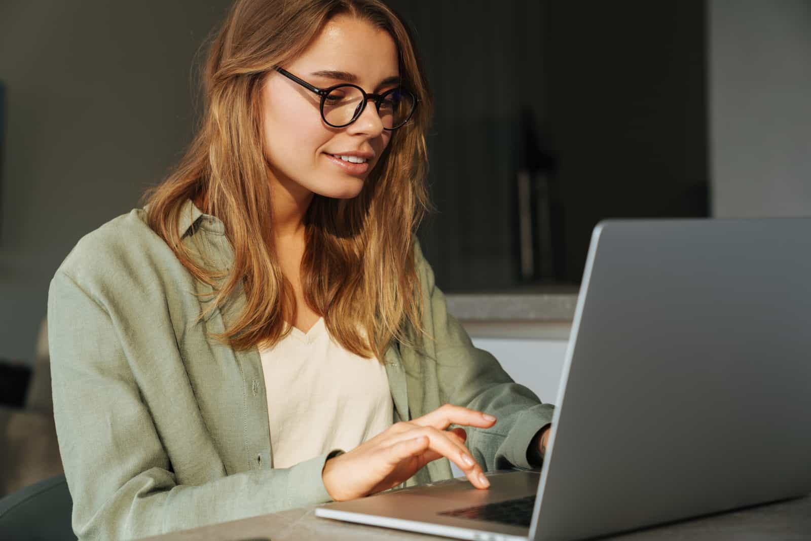 una bella donna seduta dietro un computer portatile a lavorare