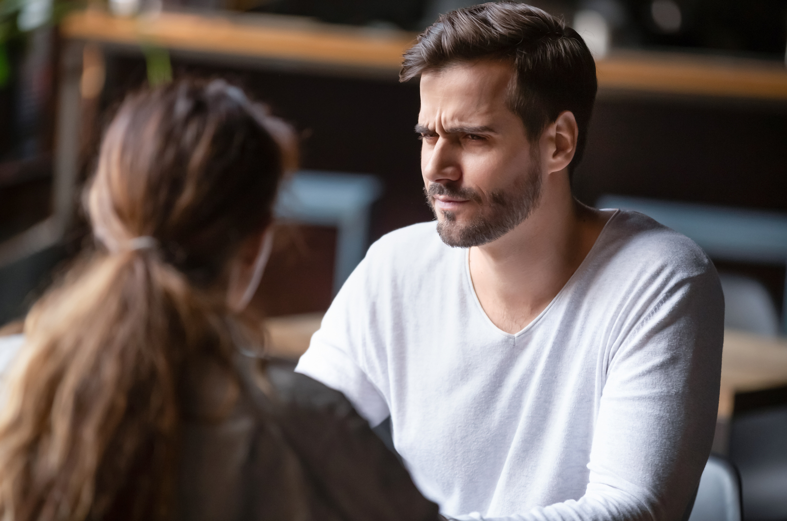 a man angrily sits next to a woman as they talk