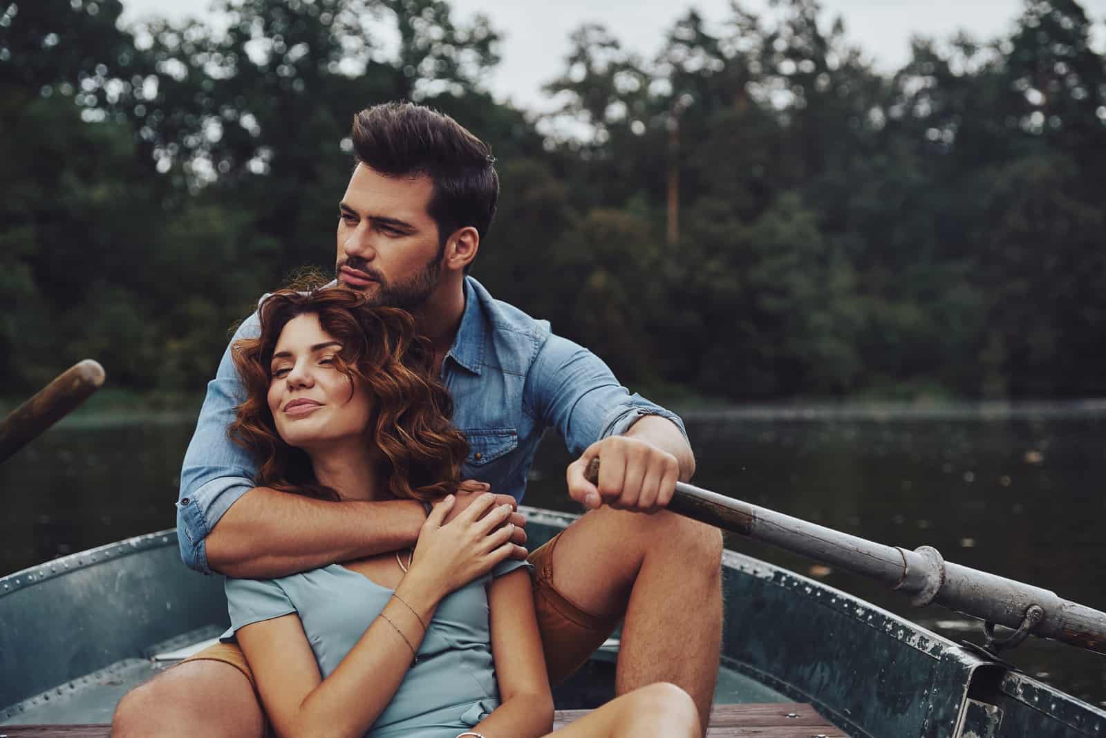 a woman in the arms of a man as they ride in a boat