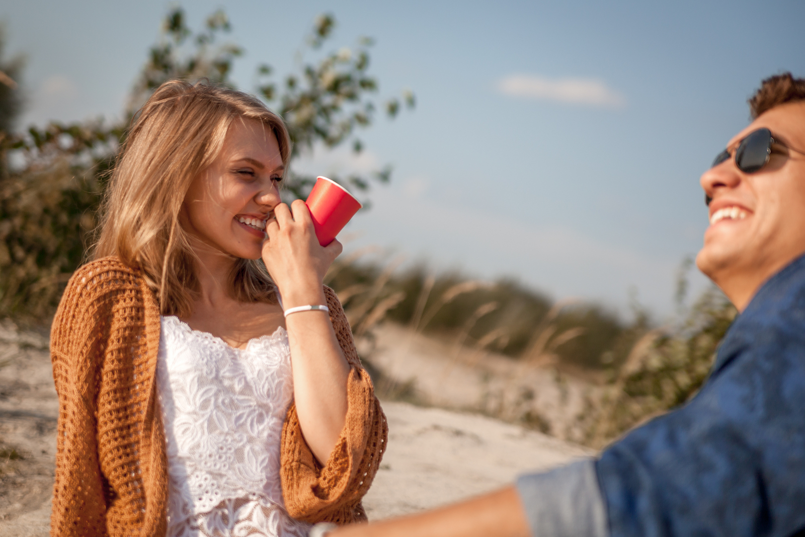 hermosa mujer riendo con el hombre en el picnic en la naturaleza