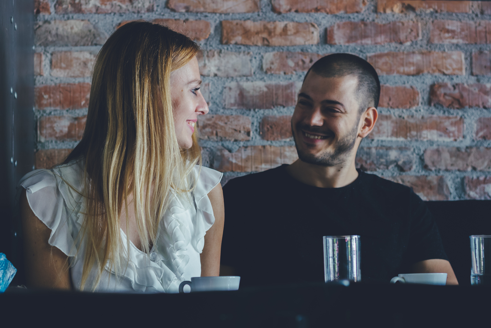 casal sentado num café a olhar um para o outro