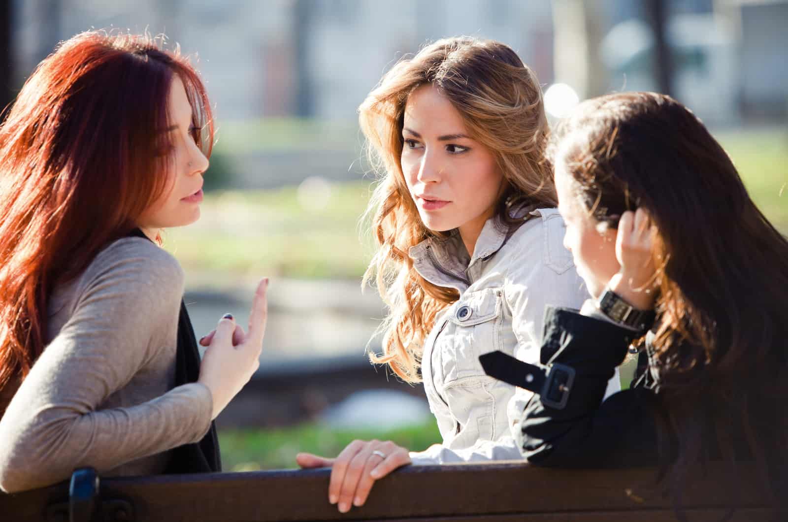 three women gossiping in park
