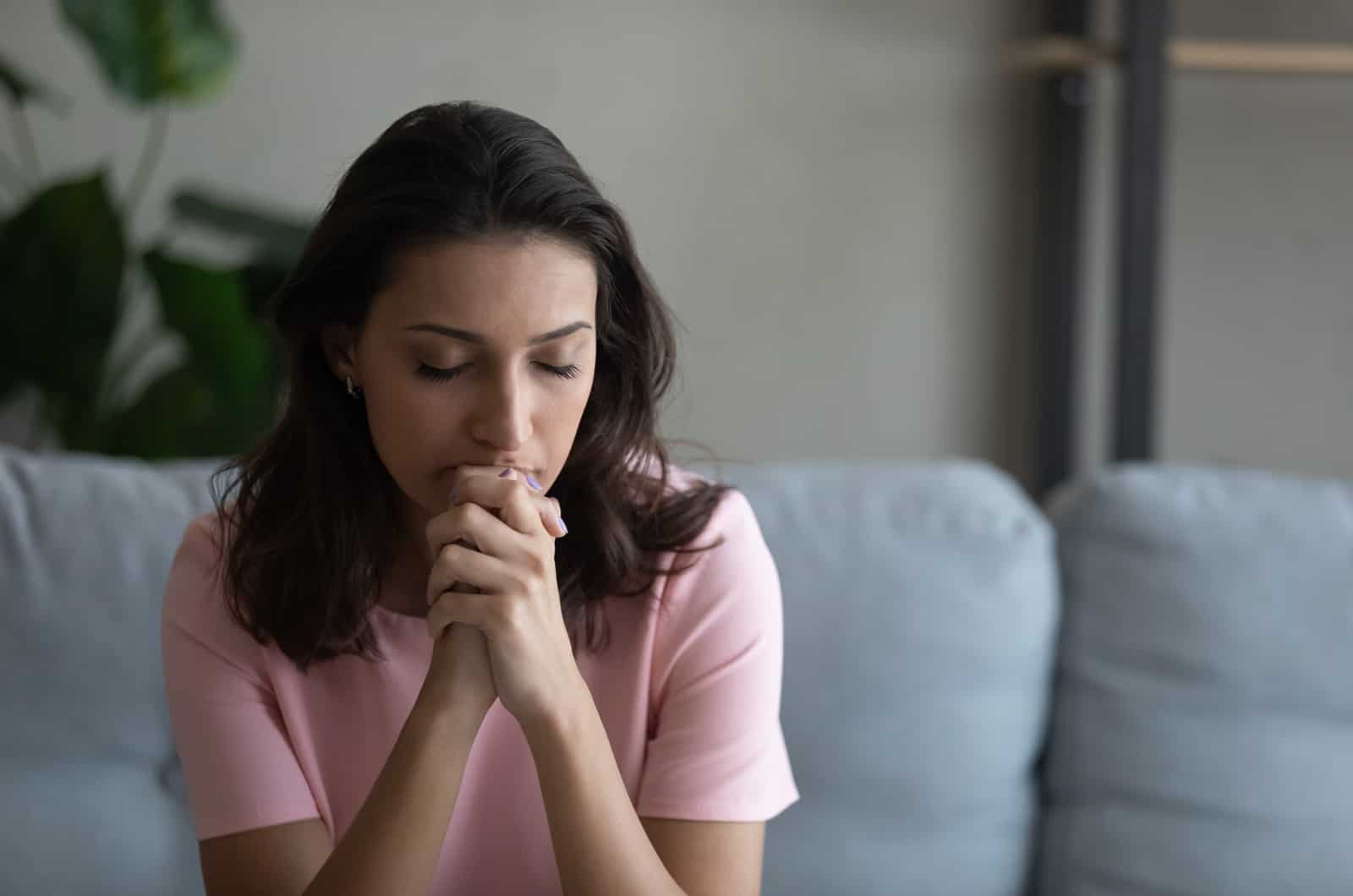 worried young woman sitting on sofa