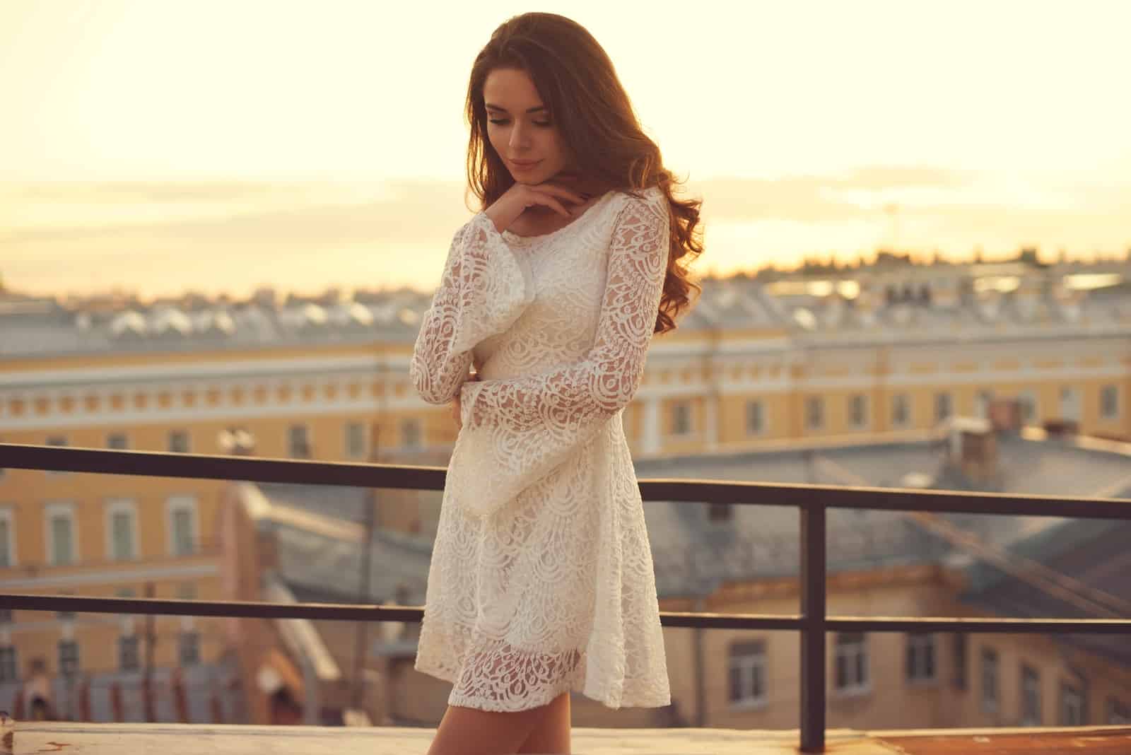 young pretty elegant girl posing at roof at sunset