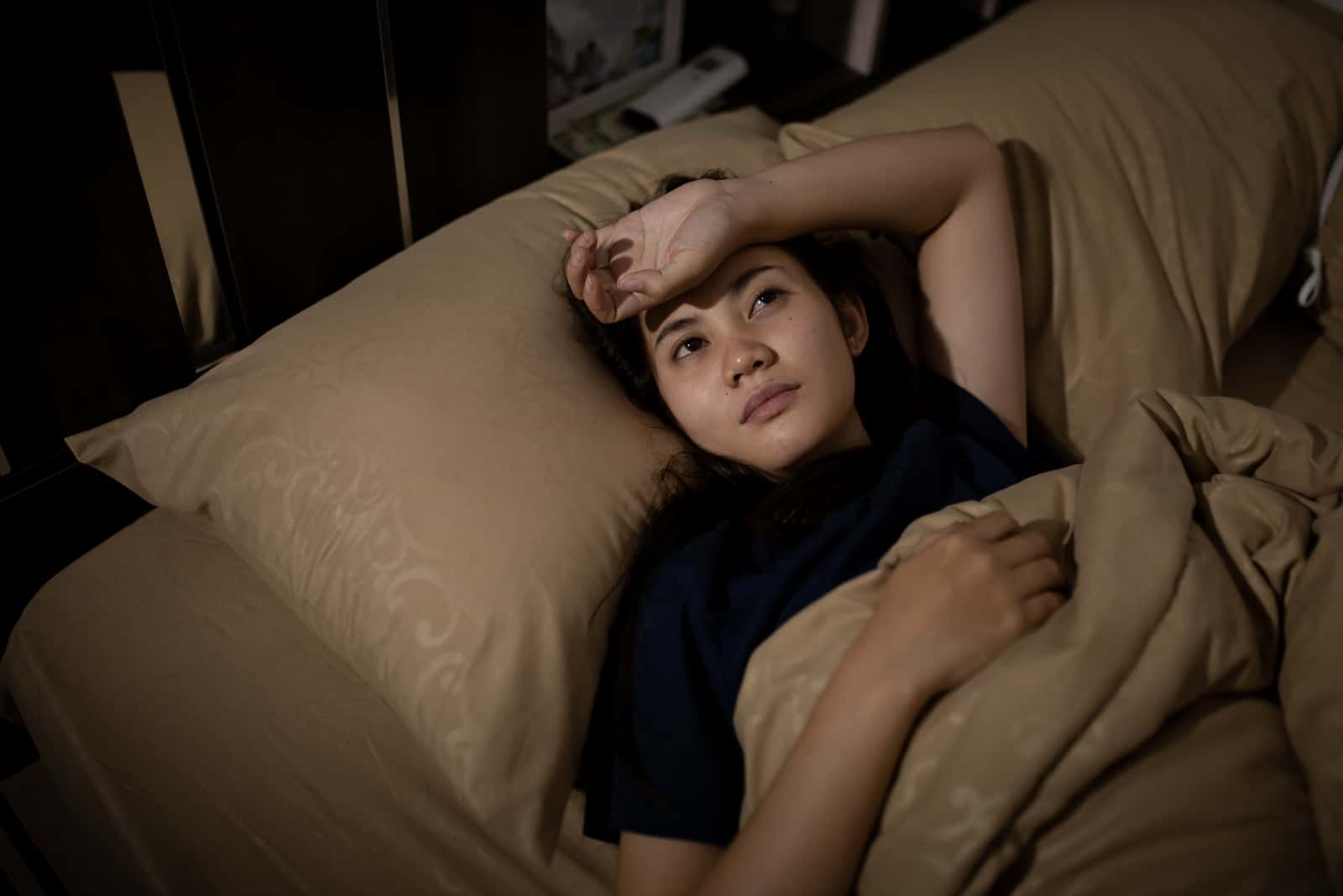 young woman laying in bed at night