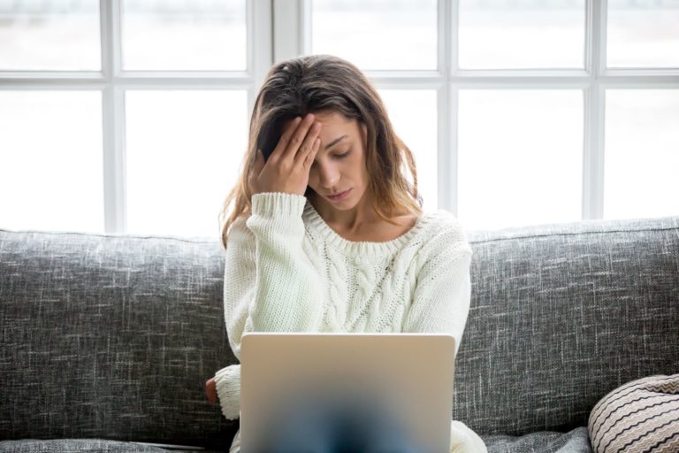 worried woman looking at laptop