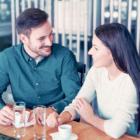 un uomo e una donna sorridenti seduti a tavola a parlare