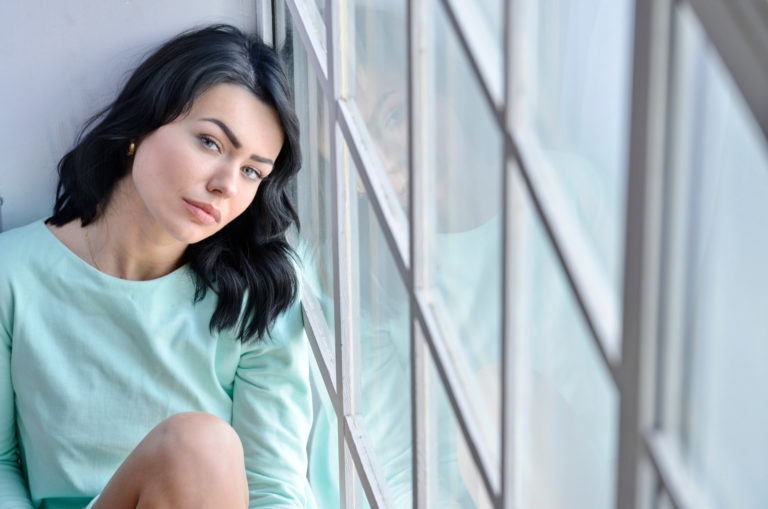 beutiful woman sitting near the window