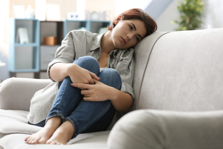 donna depressa seduta su un divano