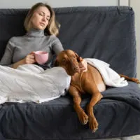 woman sitting on sofa with dog