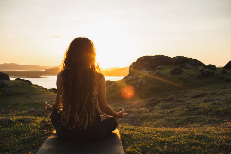 a beautiful woman with long brown hair is meditating