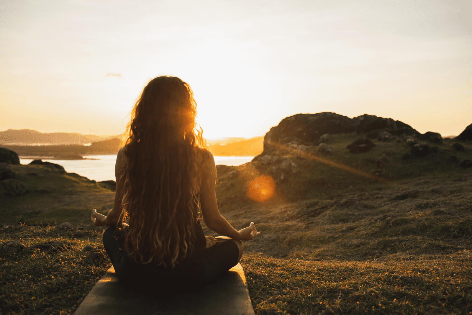 a beautiful woman with long brown hair is meditating