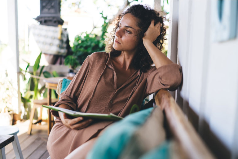 pensive woman sitting on the couch