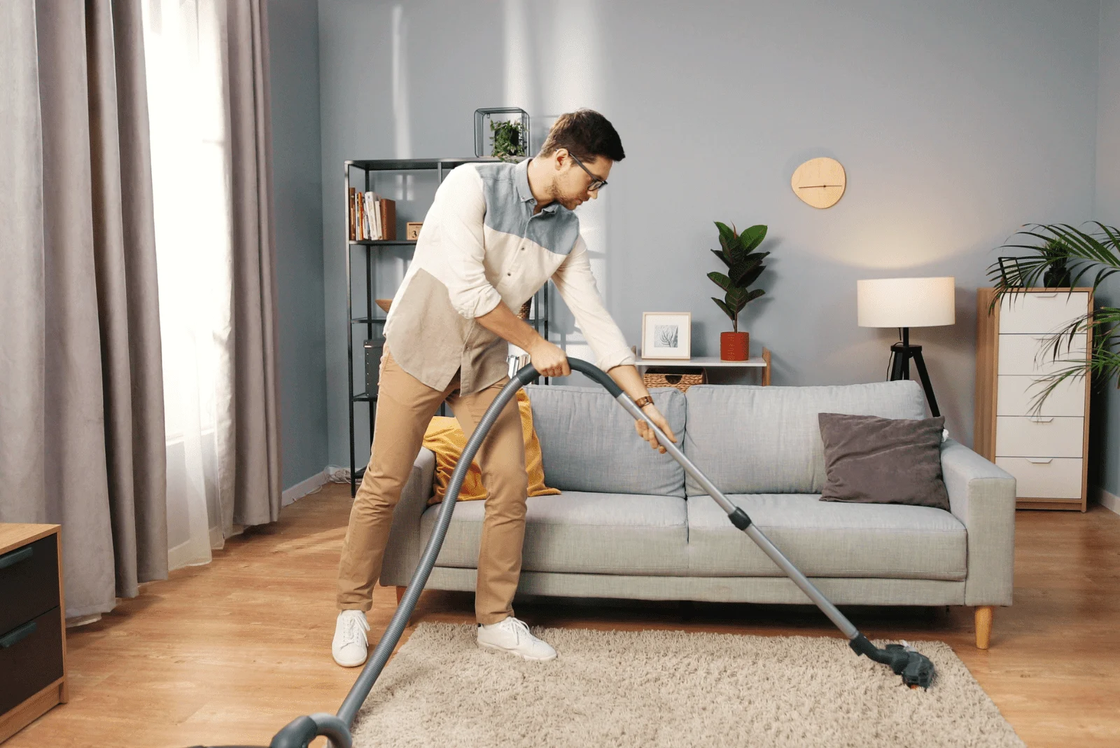 a man vacuums around the house