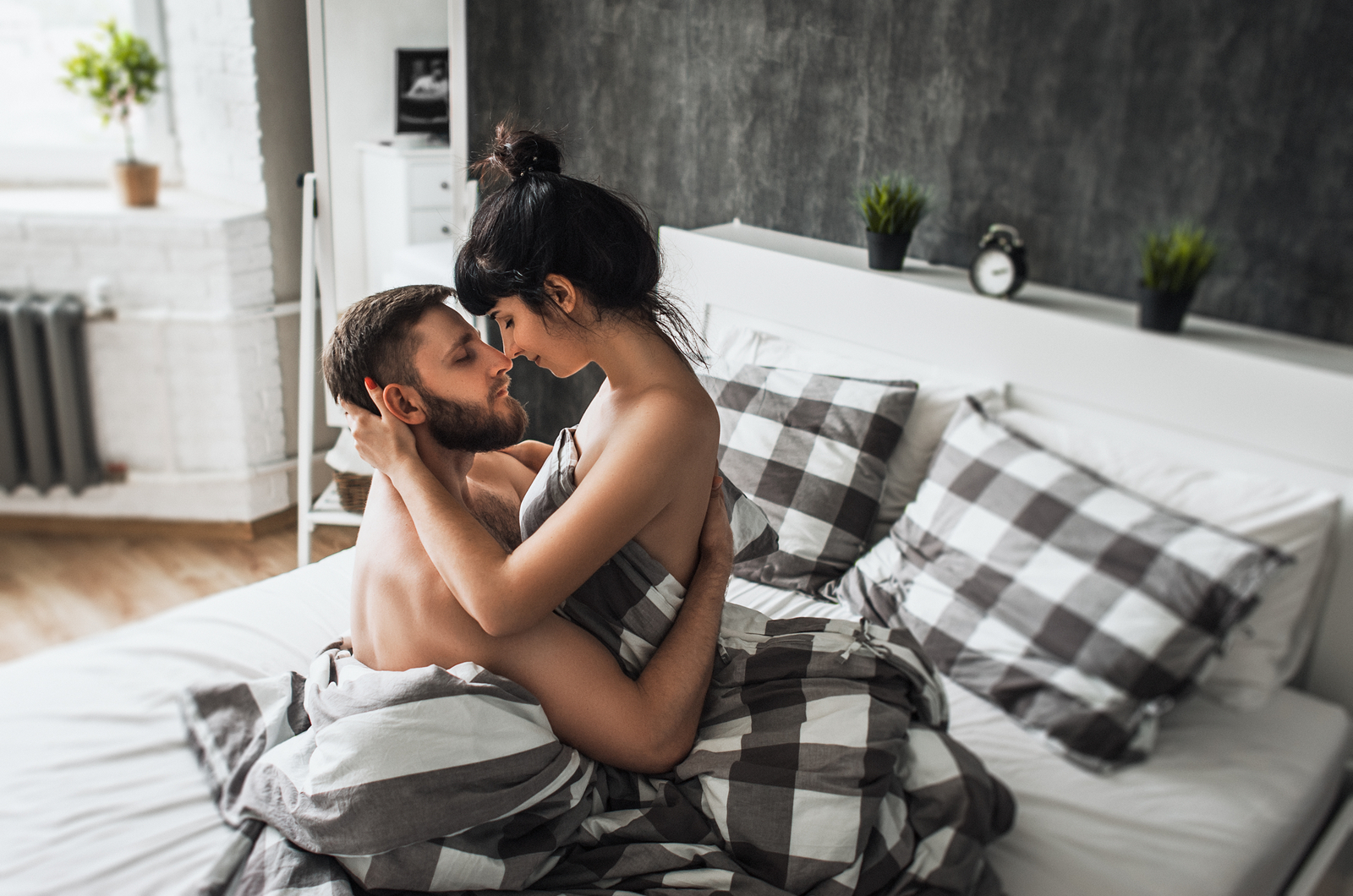 a woman and a man are cuddling in bed